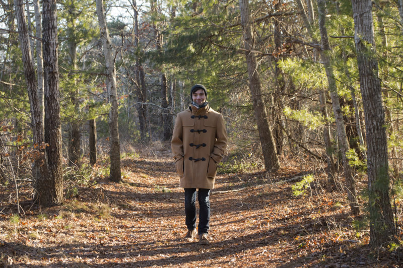 A man walking on a wide forest trail at Great Neck Conservation Area in Wareham.