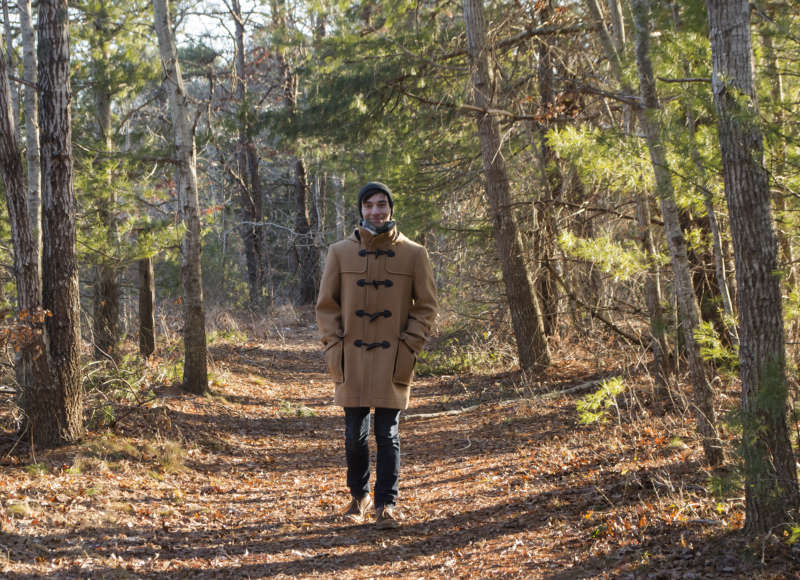 A man walking on a wide forest trail at Great Neck Conservation Area in Wareham.