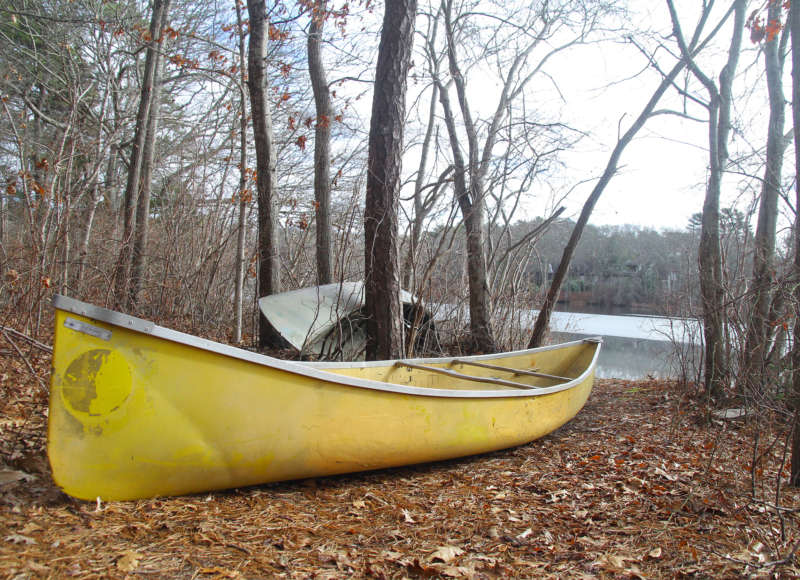 A canoe sits by the edge of Red Brook Pond in Bourne.