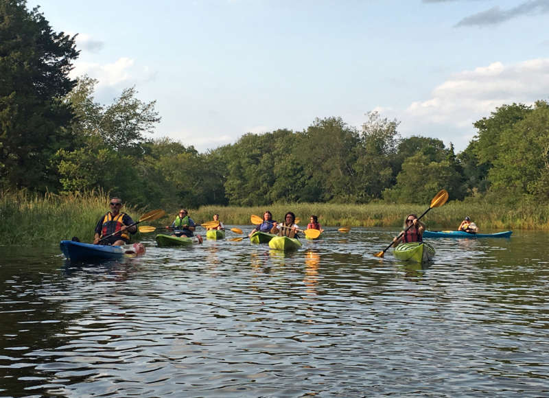 A group of people paddling on the Westport River.