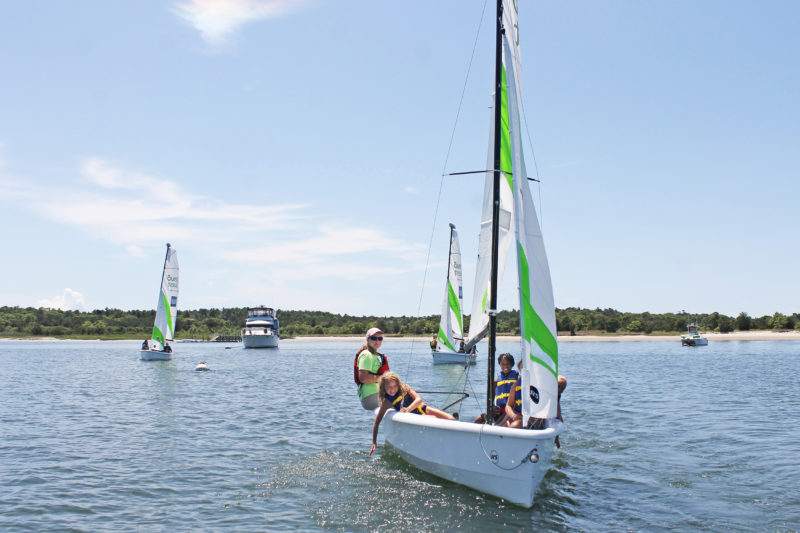 Boys and Girls club participants on a boat with a Community Boating Center instructor.