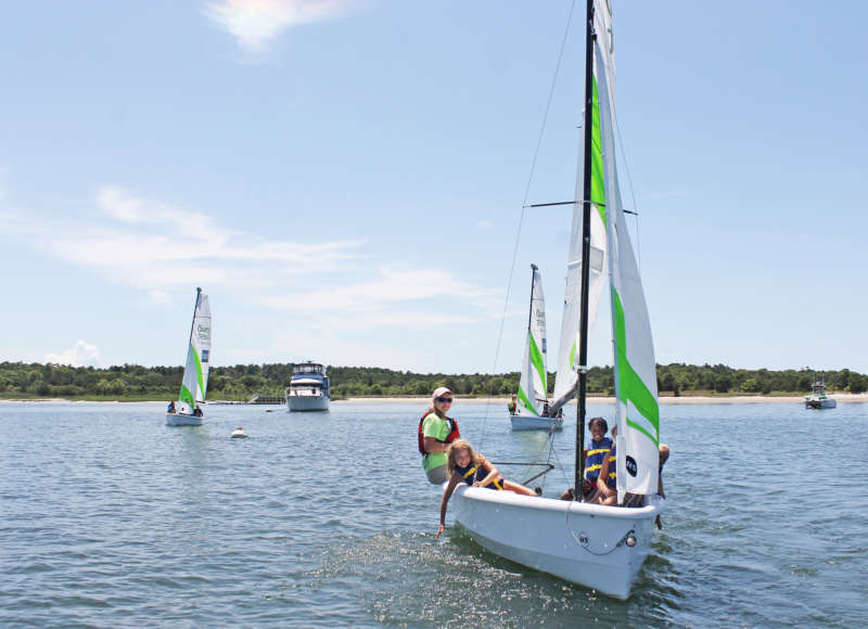 Boys and Girls club participants on a boat with a Community Boating Center instructor.