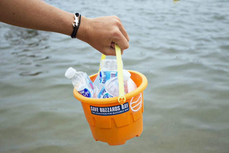 Hand holding a bucket full of trash