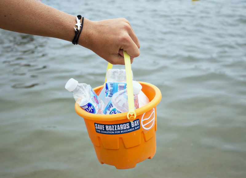 Hand holding a bucket full of trash