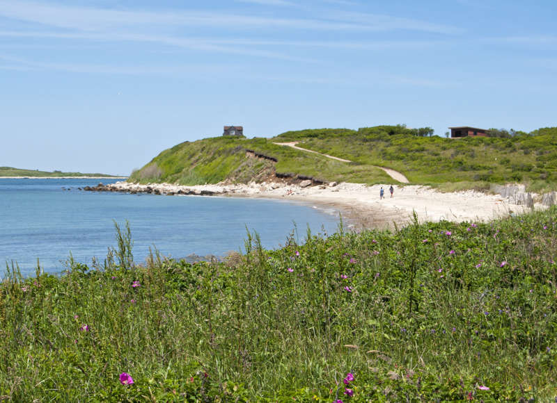 Two people walking along Church's Beach on Cuttyhunk Island.