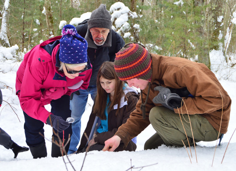 Family looking at the snow in the woods