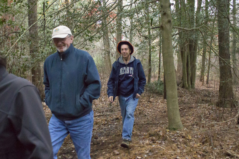 People walking through the woods on the trail at Hamlin Crossing in Acushnet