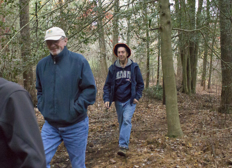 People walking through the woods on the trail at Hamlin Crossing in Acushnet