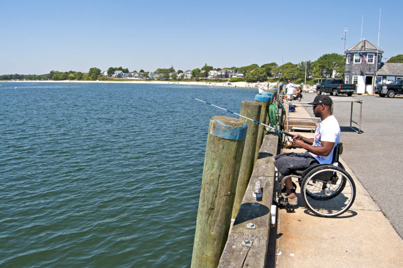 Man in wheelchair fishes from Onset Town Pier in Wareham