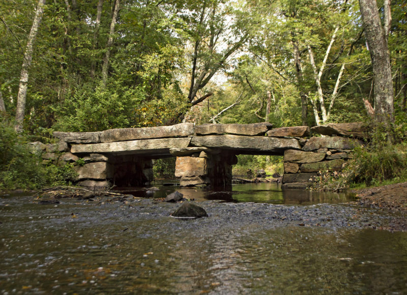 Old granite bridge over Paskamansett River at Gidley Woods in Dartmouth