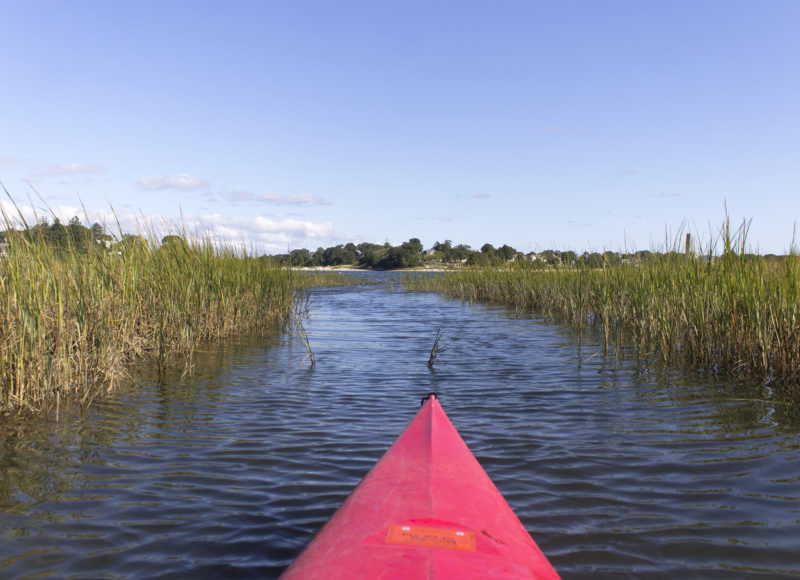 A red kayak in the salt marsh at Broad Marsh Conservation Area, looking out into Onset Bay