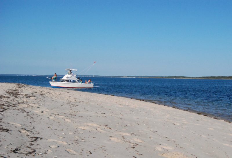 A motorboat pulled onto the sandy beach of Weepecket Island