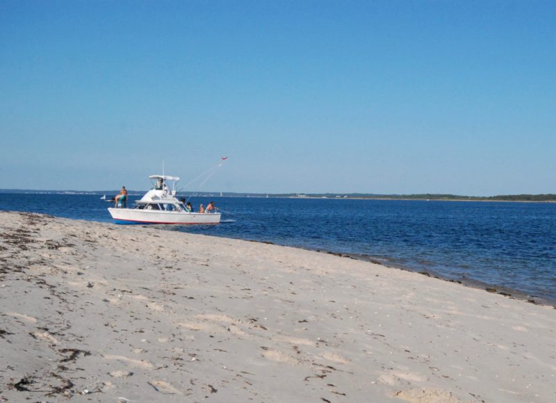 A motorboat pulled onto the sandy beach of Weepecket Island