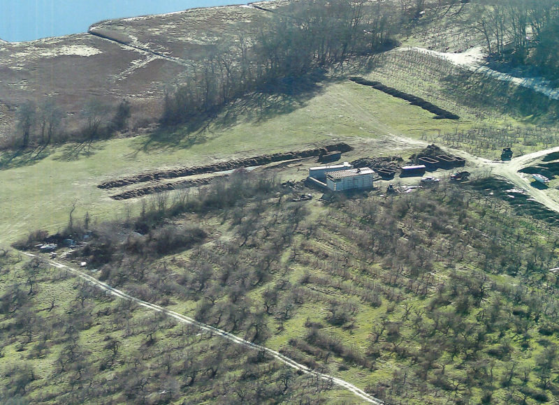 Composting materials in lines at a farm next to salt marshes