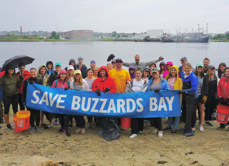 Volunteers hold a SAVE BUZZARDS BAY banner at a Marsh Island Cleanup