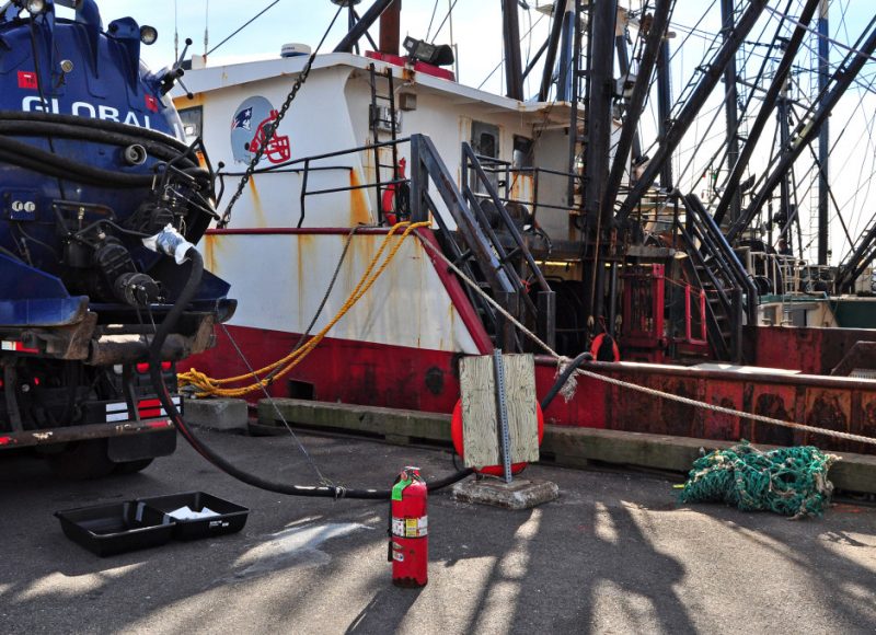A pumpout truck removes bilge water from a fishing vessel on New Bedford Harbor. This bilge water – and any oil it contains – is recycled at a collection facility instead of ending up in the harbor.