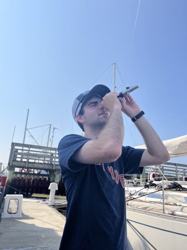 Caleb Friedman uses a refractometer to measure salinity levels at Pope's Island Marina.