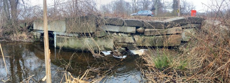 Inlet of the culvert on Snell Creek at Drift Road in Westport, MA showing the 36-inch diameter metal pipe (left side of the image) and the collapsing stonework obscuring the view of a 24-inch pipe (right side of the image).