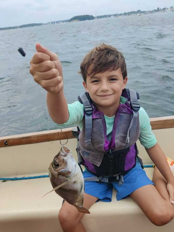 A camper holding a fish he has caught.