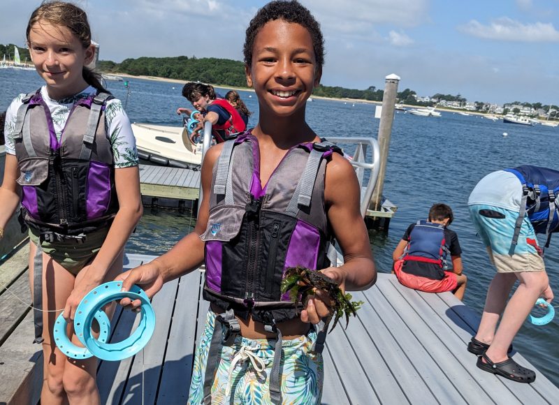 Kids show a fish they have just caught on a boat at Onset Bay.