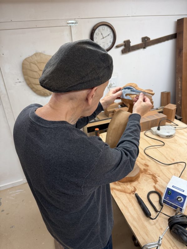 Artist John Magnan lays a photo of a heron on the sculpture's face for reference.